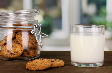 一杯牛奶对 windows 背景特写的木桌上的饼干