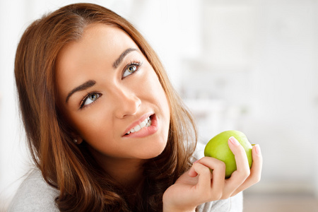 很健康的年轻女子微笑着一个绿色的苹果