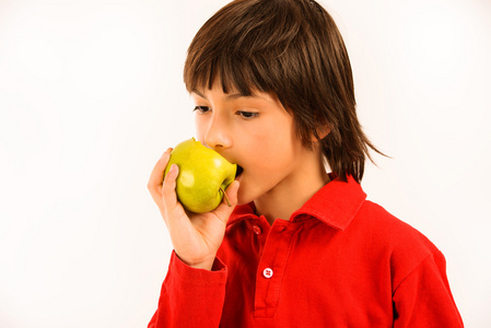 男孩吃孤立在白色背景上绿色苹果