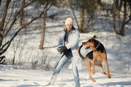 在雪地上玩狗的女孩
