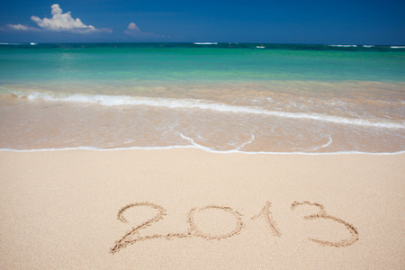 新的一年的2013手写在沙地海滩的背景