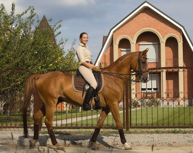 微笑骑着棕色的马在农村中的妇女