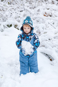 可爱的小孩男孩在冬季一天玩雪