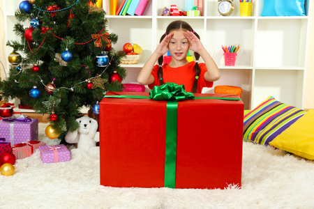 大礼品盒圣诞节树附近的小女孩
