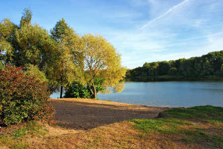 在金色的秋天的小湖岸边照片