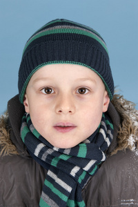 小男孩用针织的帽子和围巾的肖像