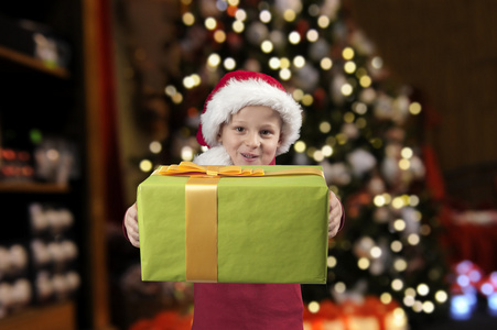 圣诞帽子和礼物在圣诞节树的男孩