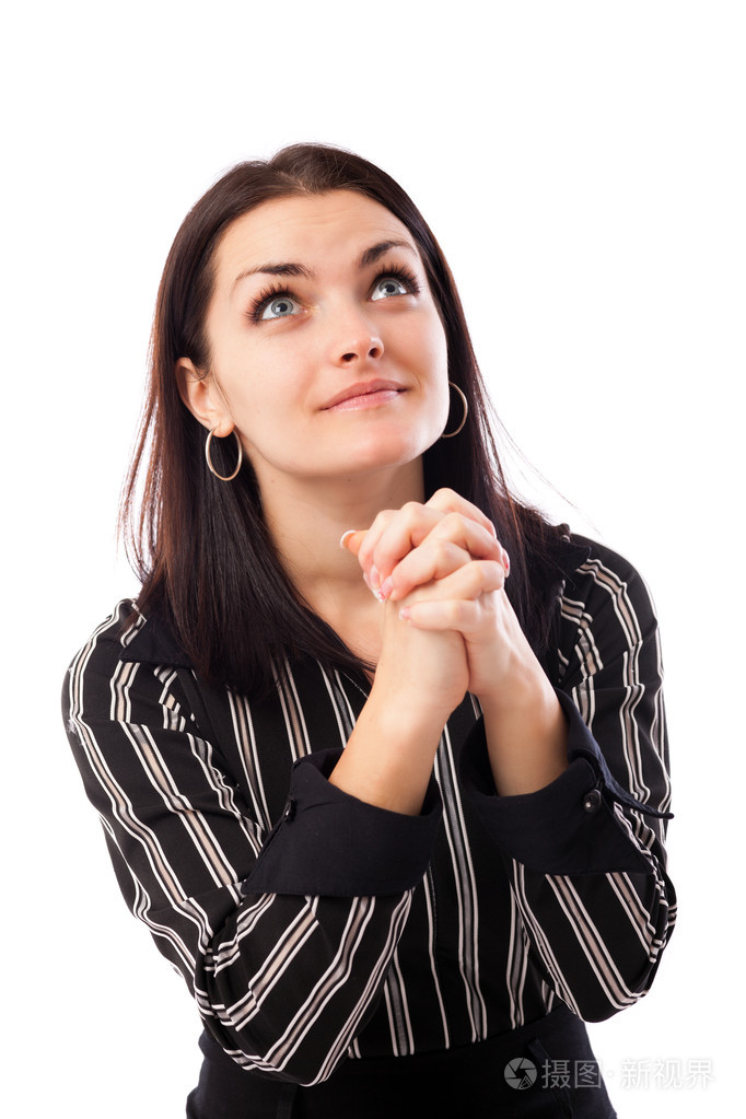 年轻女商人祈祷的同时向上看