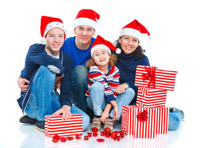 家庭在圣诞老人的帽子与礼品盒