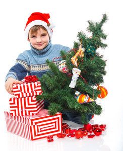 小男孩在圣诞老人的帽子与礼品盒