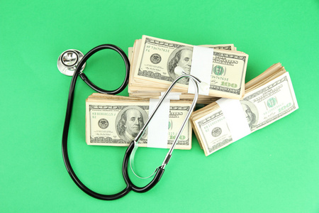 医疗成本的概念 听诊器和美元在绿色背景上