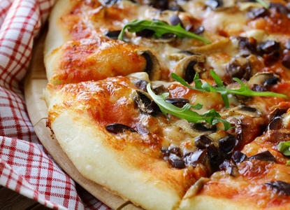 意大利比萨饼与蘑菇和橄榄在木板上