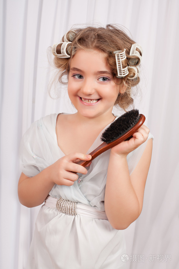 她头上的卷发的漂亮小女孩