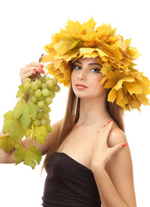 美丽的年轻女子，与黄色秋季花圈和葡萄，孤立在白色