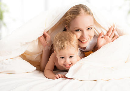 幸福的家庭母亲和孩子在床上