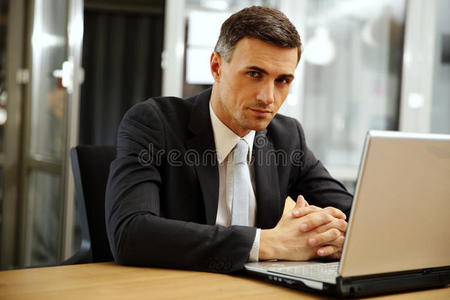 坐在笔记本电脑前沉思的商人