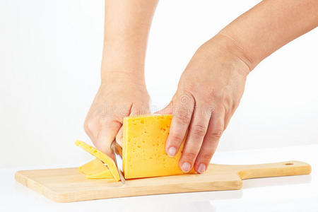 女人的手用刀切奶酪