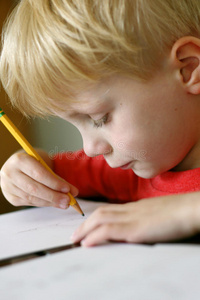 小孩子用铅笔在纸上画画