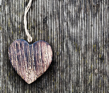 一个木头复古的心在肮脏的木板上.爱照片