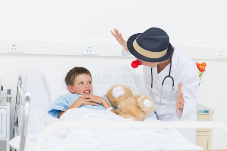 医生在病床上招待生病的男孩