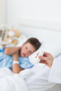 医生拿着哮喘吸入器和男孩在医院