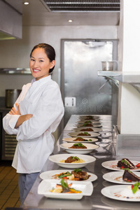 自信的女厨师除了厨房里的一排熟食