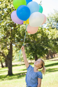 公园里拿着彩色气球的小女孩