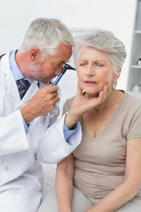 男医生检查老年病人的耳朵