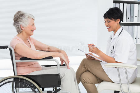 医生和一位坐在轮椅上的老年病人交谈