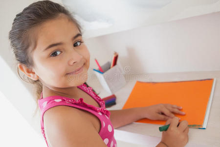 小女孩在橘色纸上画画