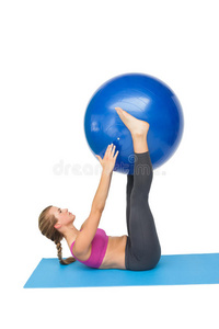 一个健康的女人用健身球锻炼的侧视图