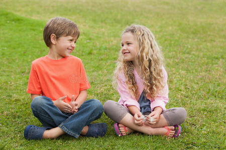 两个微笑的孩子坐在公园里