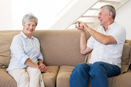 退休男子在沙发上给他的搭档拍照