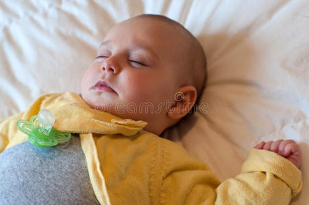 一个婴儿用奶嘴睡在床上