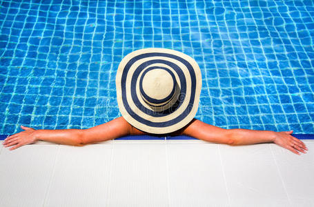 戴草帽的女人放松游泳池