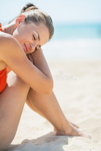 坐在沙滩上放松的年轻女子