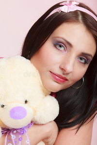 幼稚的年轻女子婴儿女孩粉红色拥抱泰迪熊玩具