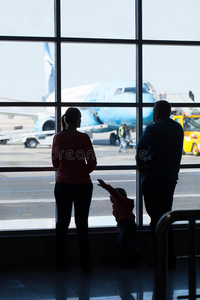 在机场看飞机的年轻家庭