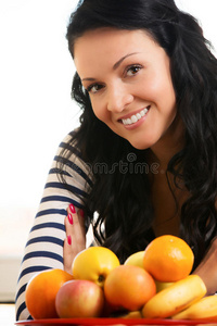 美丽的年轻女人，在水果篮前微笑