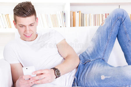现代人用智能手机在家里的沙发上放松
