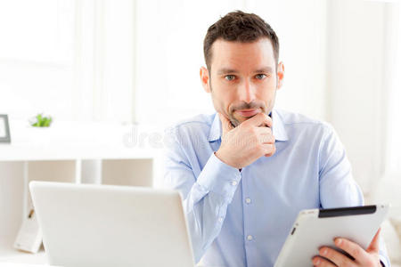 年轻的商人在家里用他的平板电脑工作
