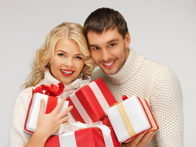 一对浪漫的情侣穿着毛衣和礼品盒
