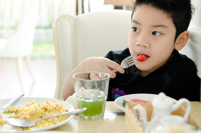 吃西瓜片的亚洲男孩。