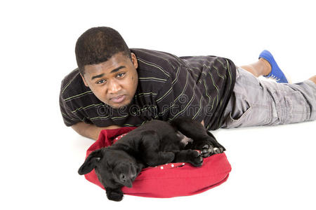 非洲裔美国人躺在拉布拉多小狗旁边