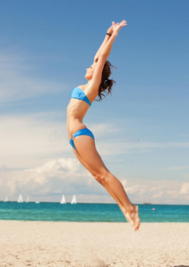 海滩上快乐的跳跃女人