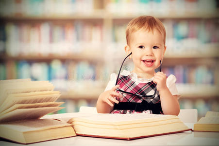 戴眼镜的滑稽女婴在图书馆看书