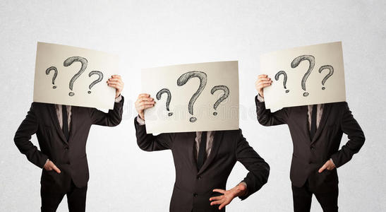 困惑的男人用纸板上的问号做正式手势照片