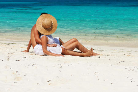 一对白衣夫妇在马尔代夫的海滩上放松