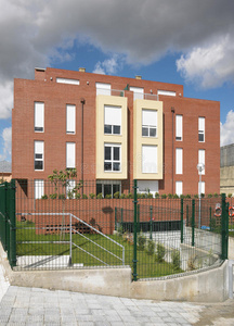 现代公寓橙色砖立面带围栏。