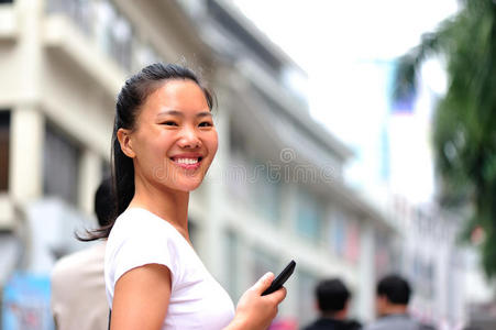 亚洲女性在购物街使用智能手机